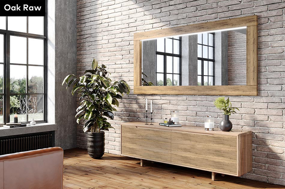 Modern interior with wooden sideboard, Oak Raw wooden framed mirror, and plants against a brick wall.