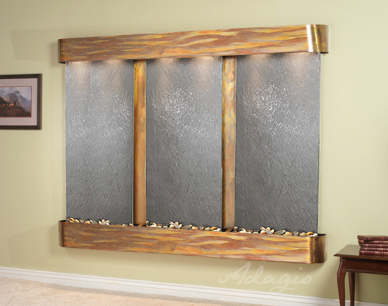 Wall-mounted water feature with black featherstone panels and bronze frame on a beige wall.