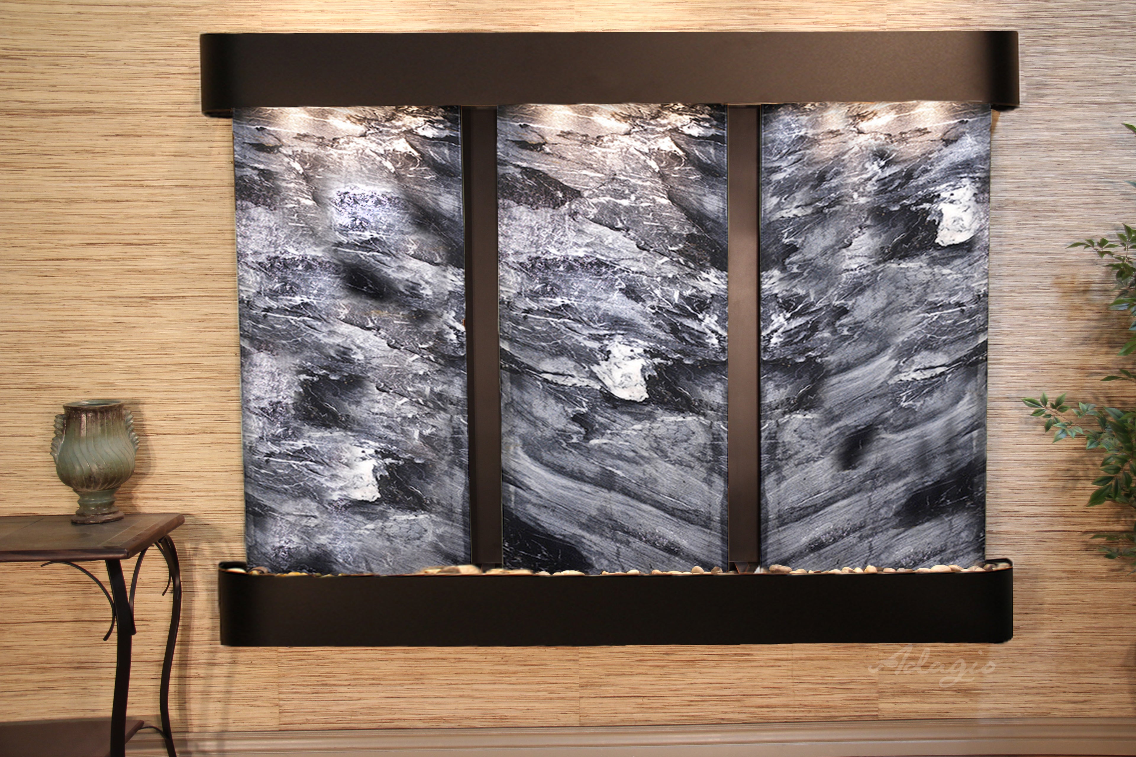 Wall-mounted water feature with black spider marble on a wooden wall.