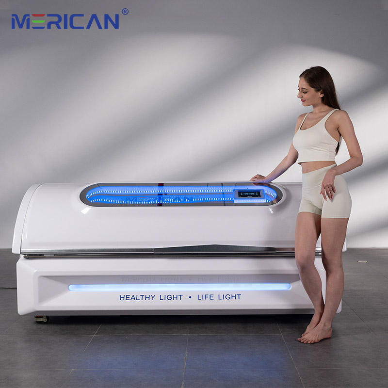 Woman standing next to a white red light bed device with blue lights, branded 'MERICAN'.