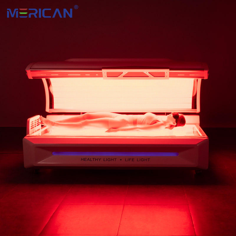 Person lying inside a red light therapy bed with 'MERICAN' branding.