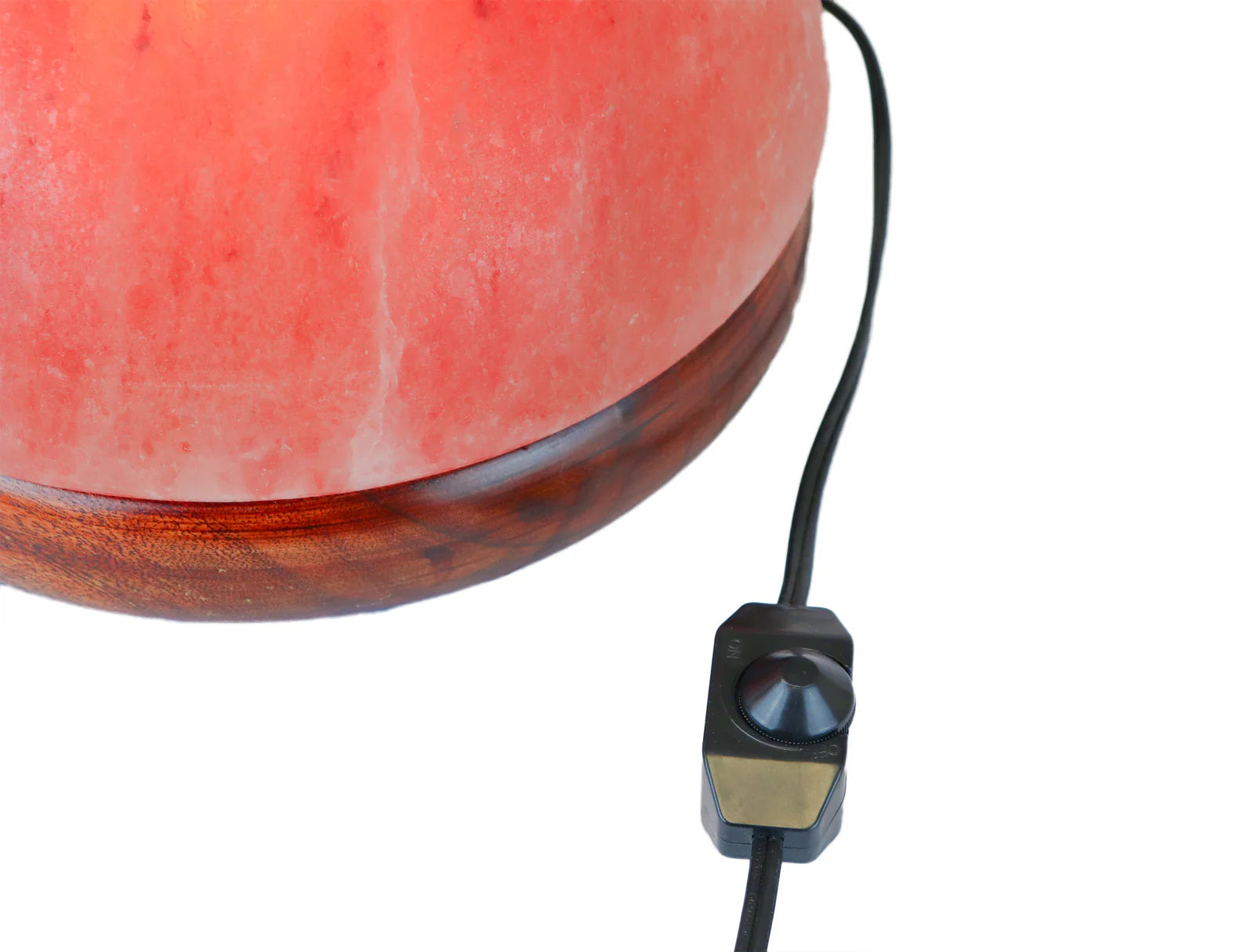 Himalayan salt lamp with wooden base and black power cord on a white background