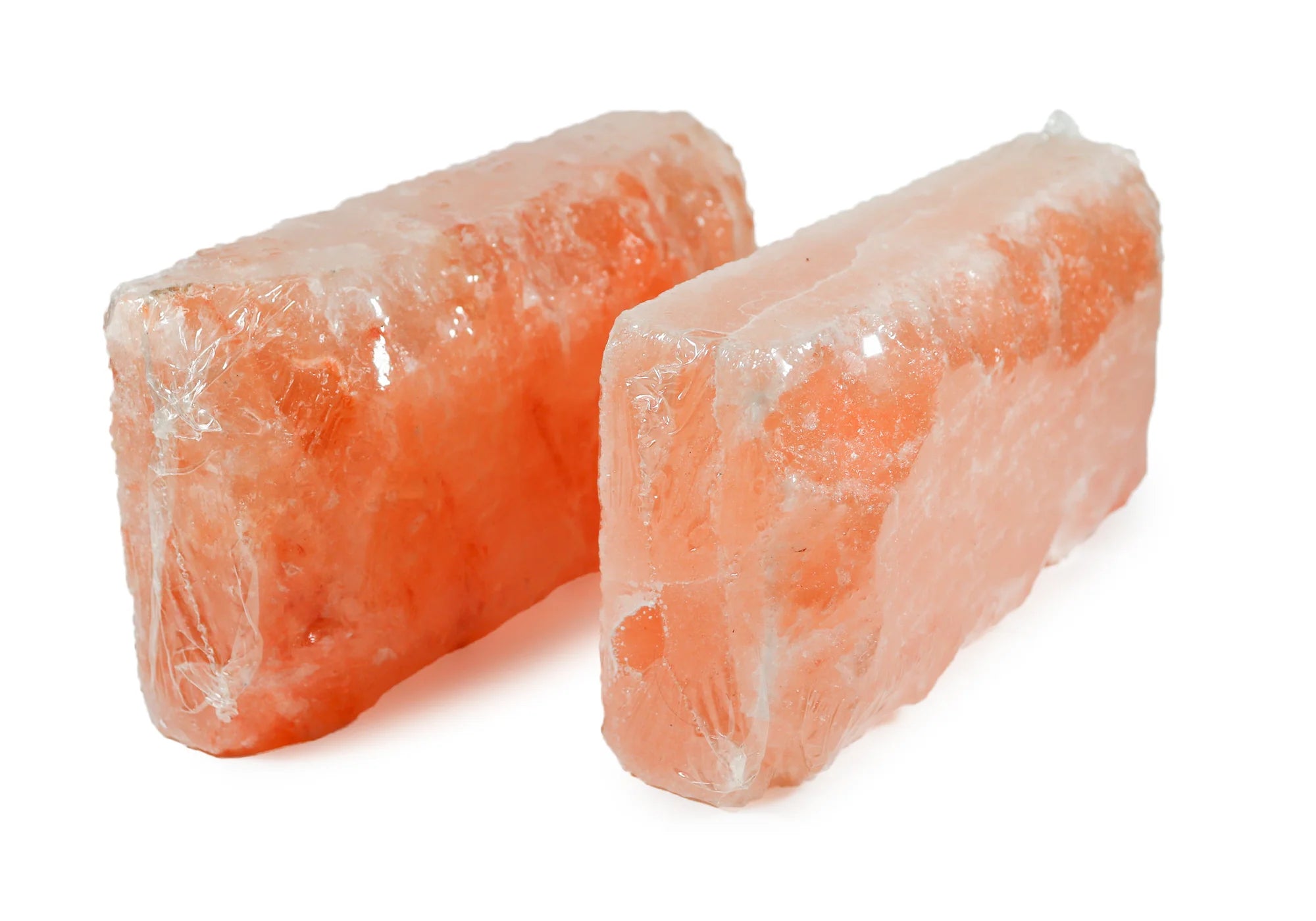 Two blocks of pink Himalayan salt on a white background