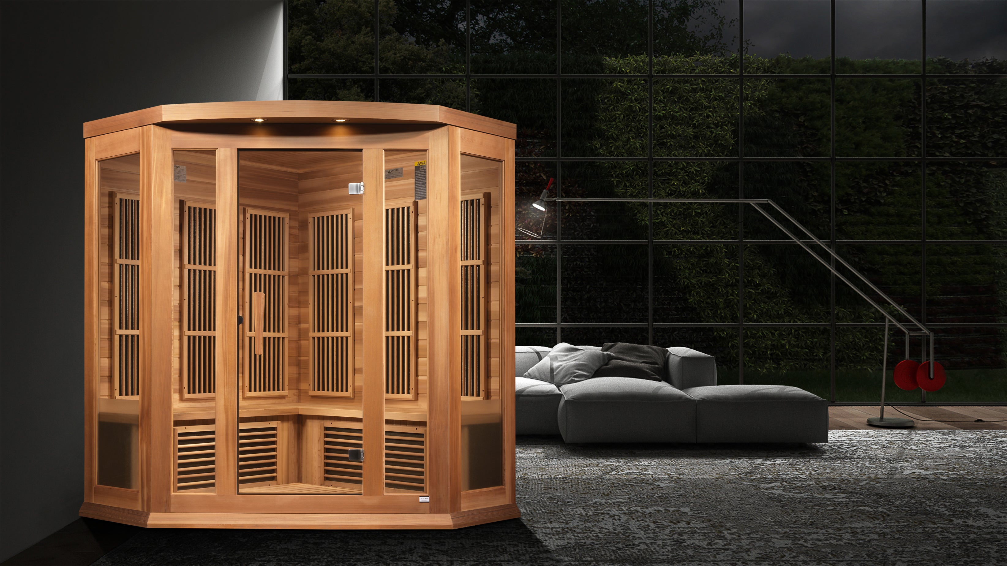 Wooden sauna in a modern living room setting with gray sofa and dark walls.