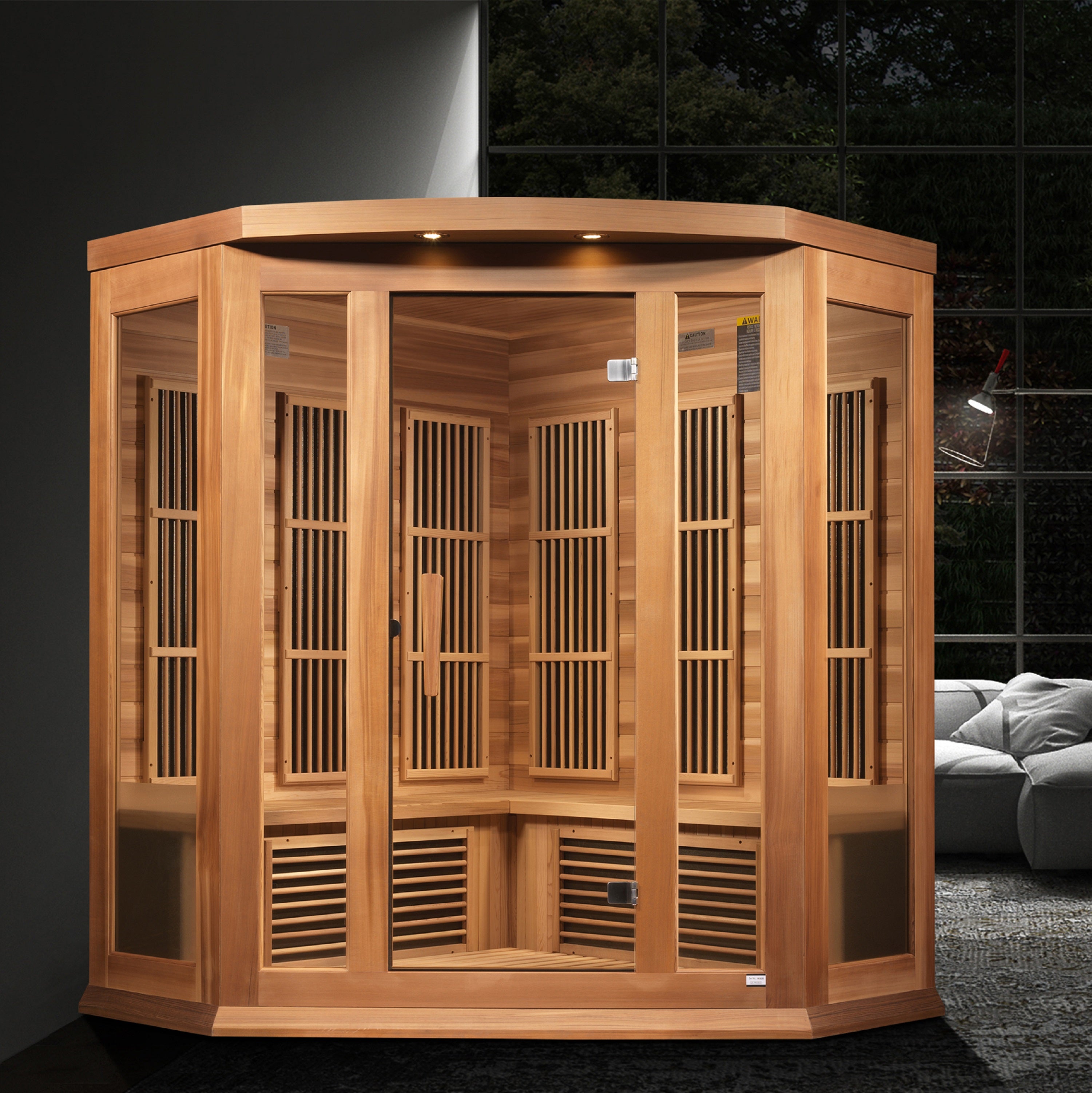 Wooden sauna cabin in a room with a dark tiled wall and gray sofa.