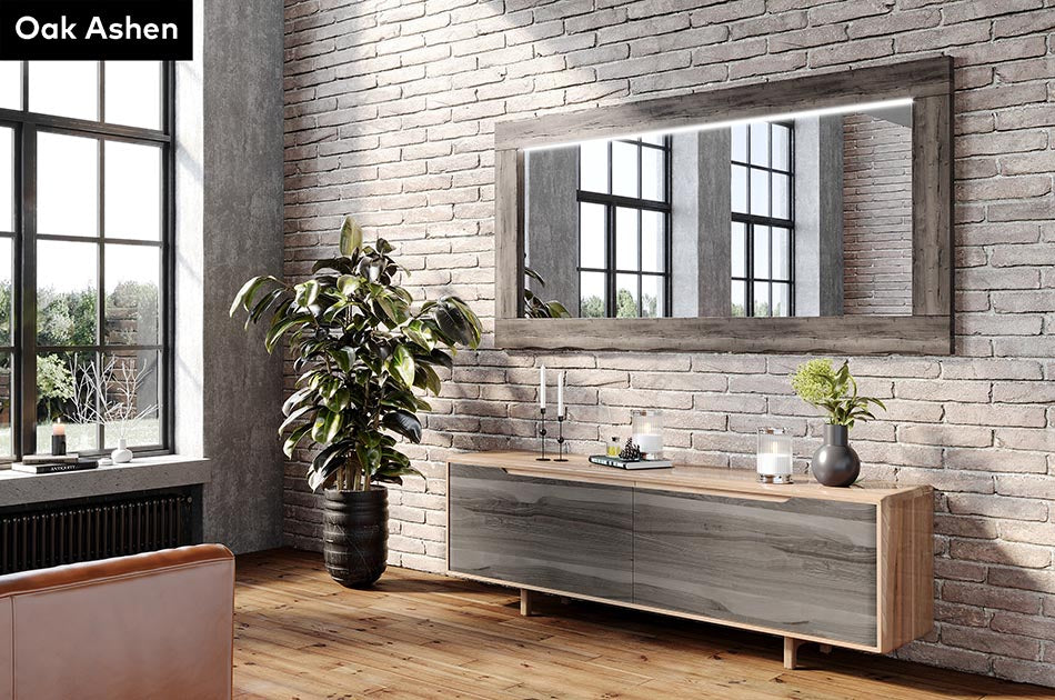 Modern interior with a wooden console table, Oak Ashen wood-framed mirror, and plants against a brick wall.