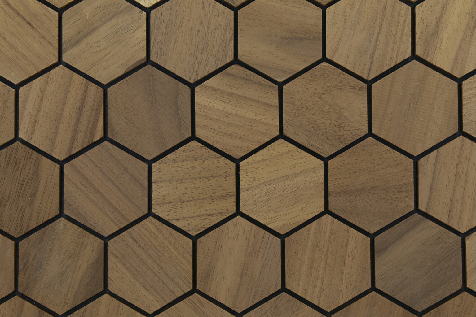 Hexagonal wood-patterned tiles with black lines on a wooden surface
