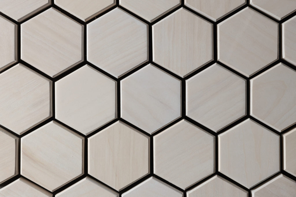 Hexagonal tiles with a neutral color palette on a tiled wall.