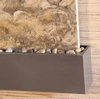 Bronze Silverado trim with stones against a stone wall
