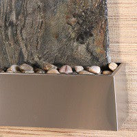 stainless steel water feature with pebbles and stone wall
