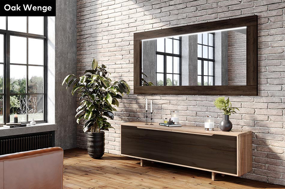 Modern interior with a wooden console table, Oak Wenge wood-framed mirror, and plants against a brick wall.