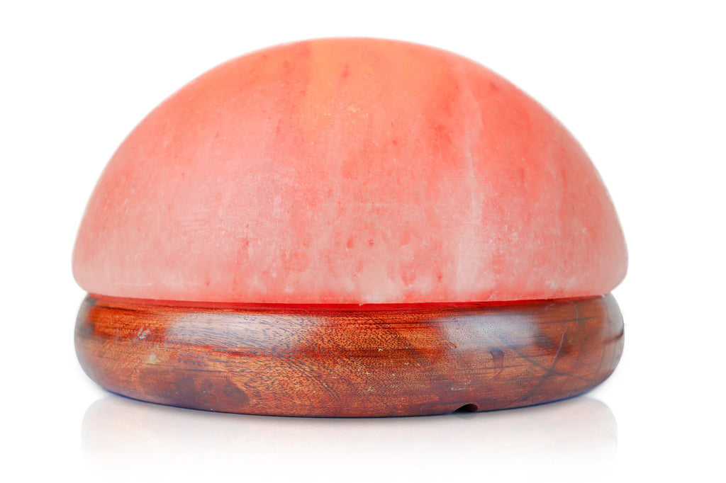 Round pink salt stone with wooden base on a white background