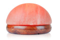 Round pink salt stone with wooden base on a white background